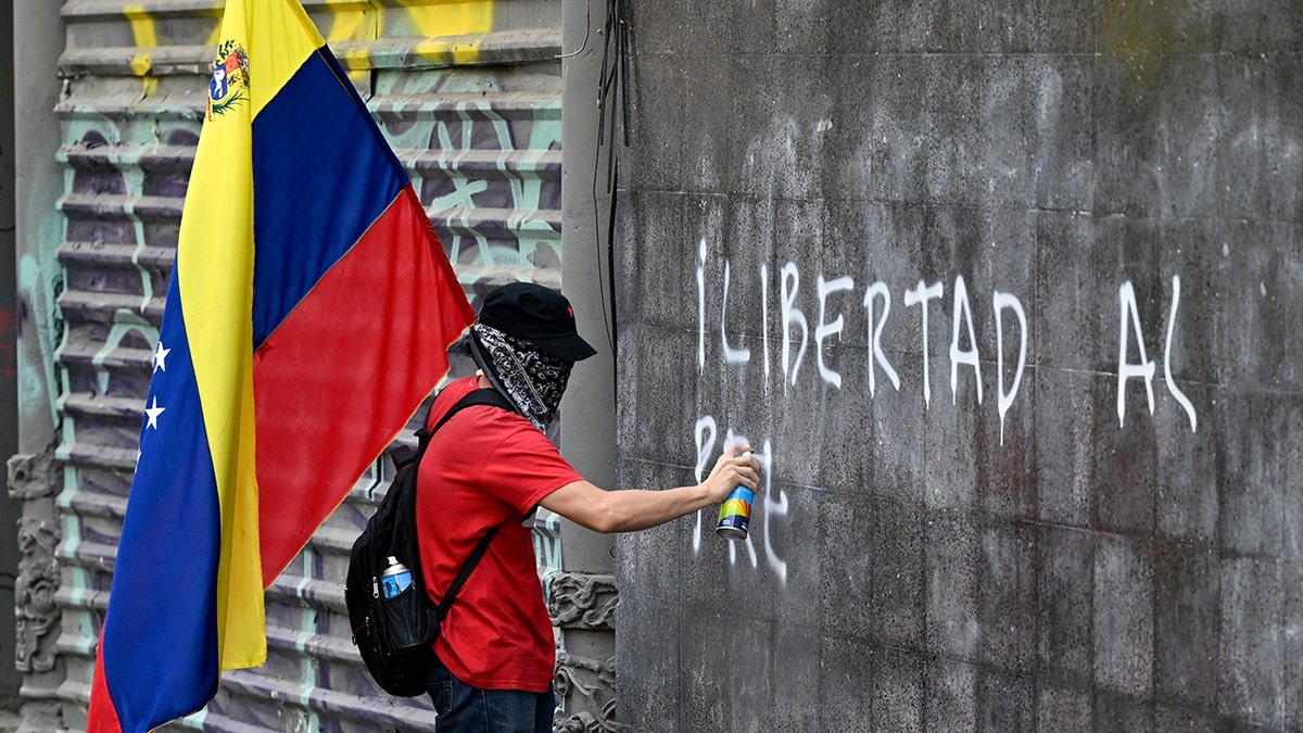 Pro-Maduro protester vandalizes city wall