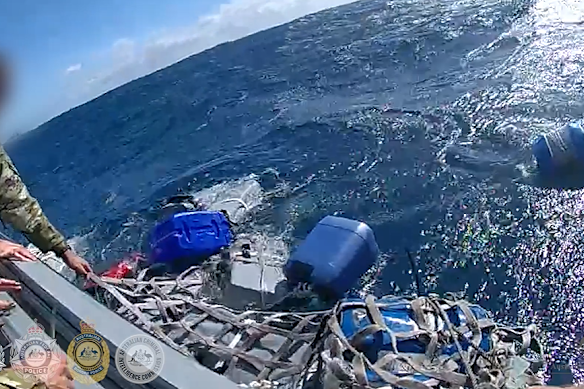 Officers pull the cocaine blocks aboard.