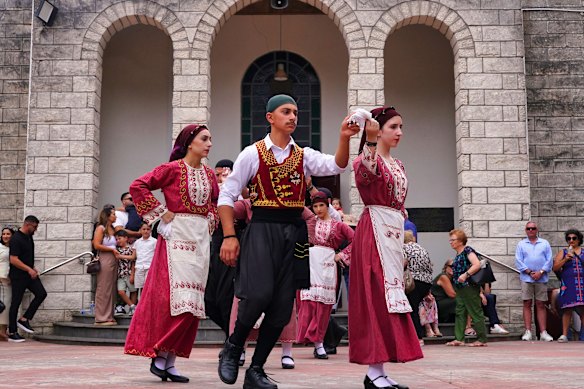 Dancers perform in front of Panagia Kamariani Greek Orthodox Church.