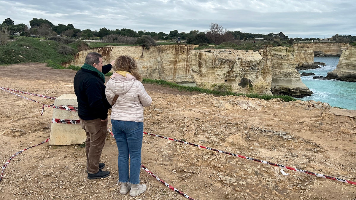 People stand near where Lovers' Arch collapsed in Italy
