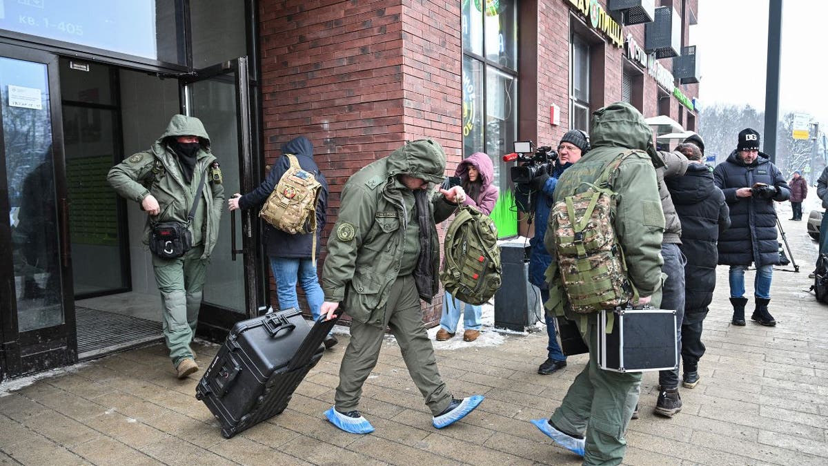 Russian investigators outside a Moscow apartment building after a general was shot
