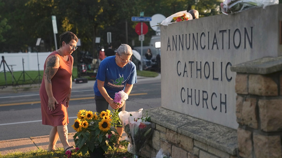 Mourners visit a memorial set up for victims of the mass school shooting at a Catholic school church.