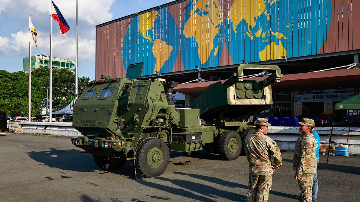 American soldiers in front of a M142 High Mobility Artillery Rocket System