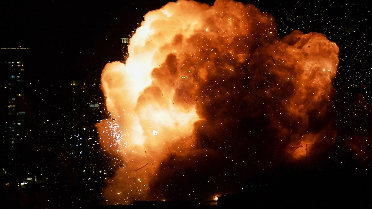 An explosion illuminating the night sky as a missile strikes a building in Tel Aviv.