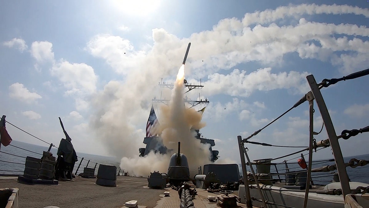A missile being launched from the deck of a U.S. Navy ship into the sky.
