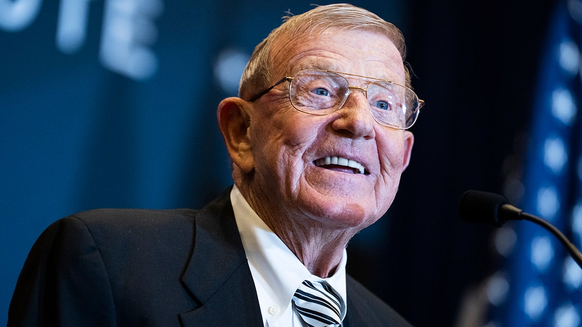 Lou Holtz smiling at podium