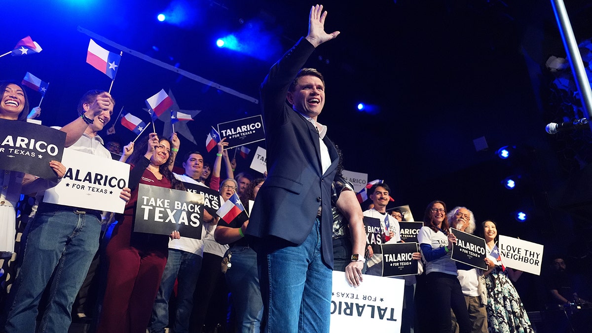 James Talarico waving while standing on a stage in Austin.