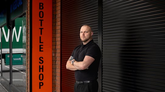 Chris Thompson outside his bottle shop in Oakleigh that will have to take down its roller shutter soon.