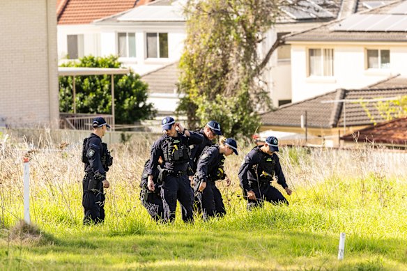 Police conduct a line search outside the Casula property on Tuesday.