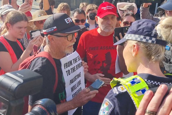 Mark Gillespie is warned by police for brandishing a sign reading “from the sea to the river” while Parry fronts court.