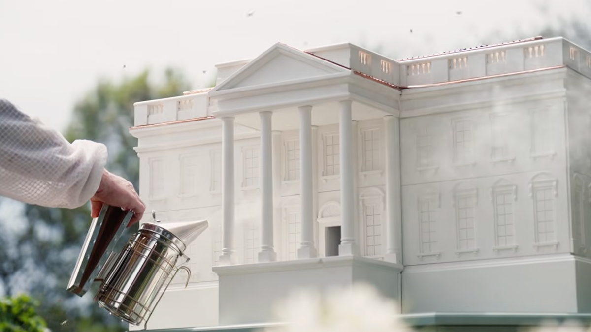 A worker sprays gas on the replica Executive Mansion hive.