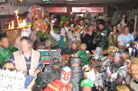 Ben Roberts-Smith, highlighted, back left, smiles and pumps his fist as a soldier in a Ku Klux Klan outfit burns a cross.