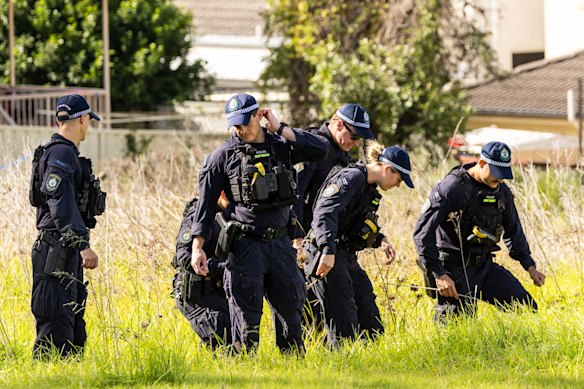 Police conduct a line search outside the Casula property.