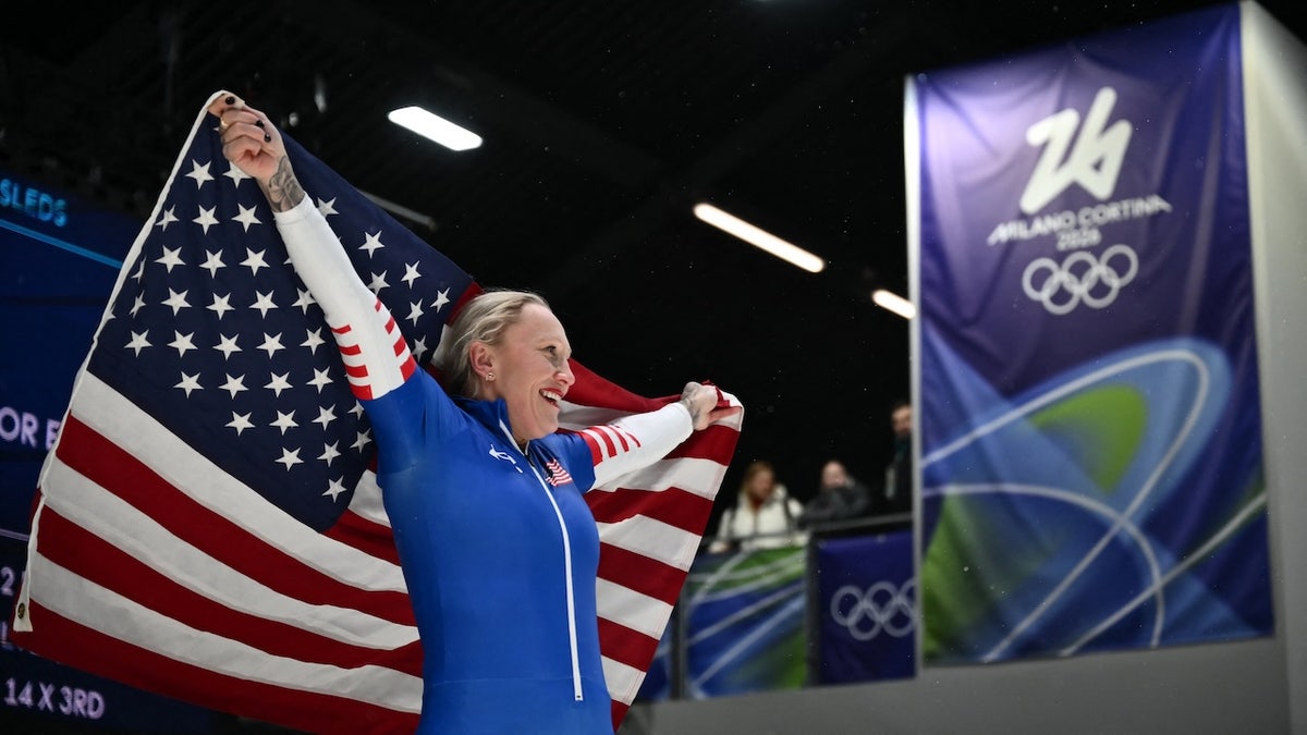 Kaillie Humphries holding a USA flag after bobsleigh women's monobob race