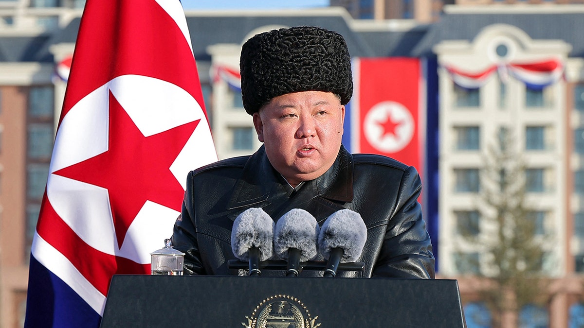 Kim Jong Un stands at a podium.