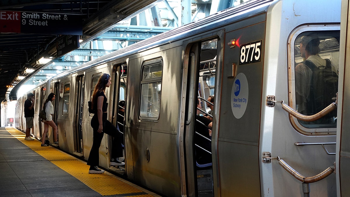 People boarding an F-line train at Smith Street - 9th Street subway station in New York City