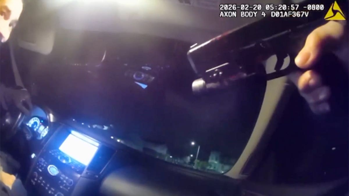 Officer Travis Donaldson pointing a gun at alleged armed robbery suspect Dominick Desouza inside a car