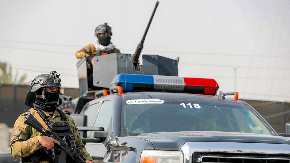 Iraqi security forces standing guard during a funerary procession in Baghdad