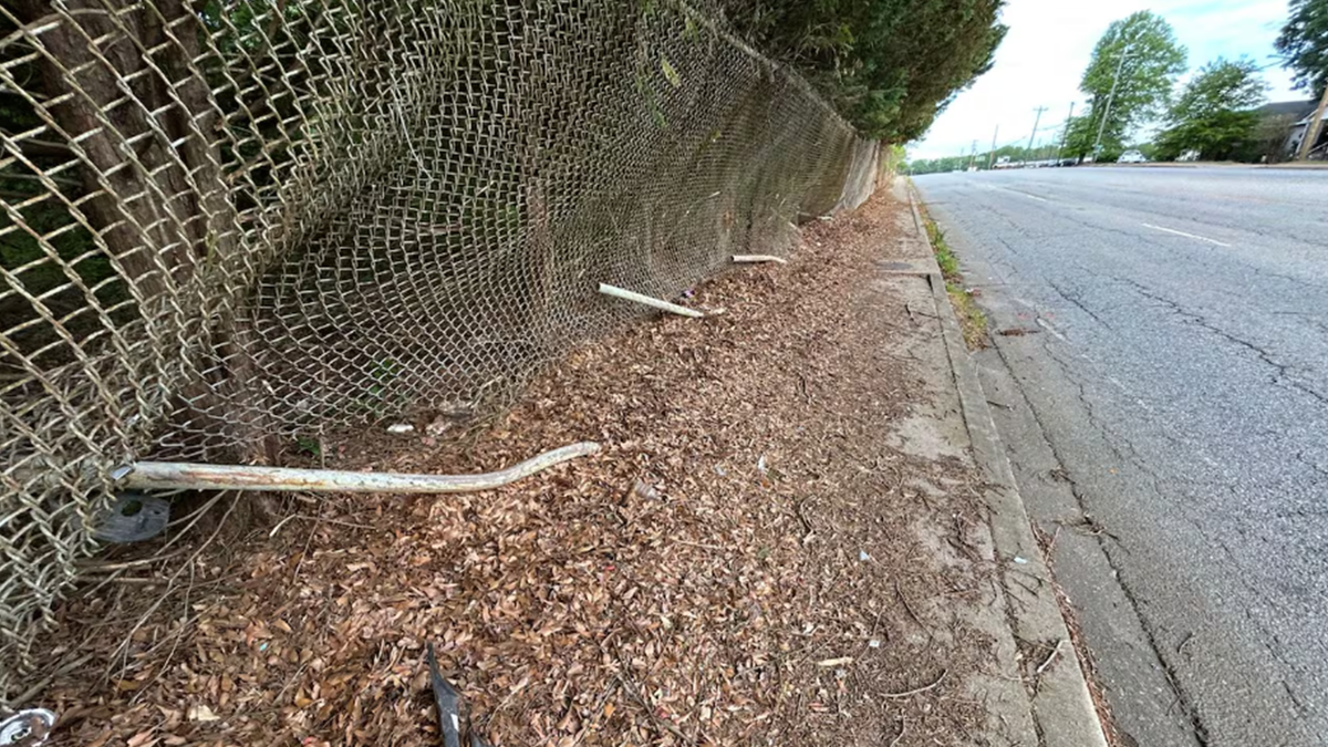 A photo showed damage to the sidewalk fence at the scene.