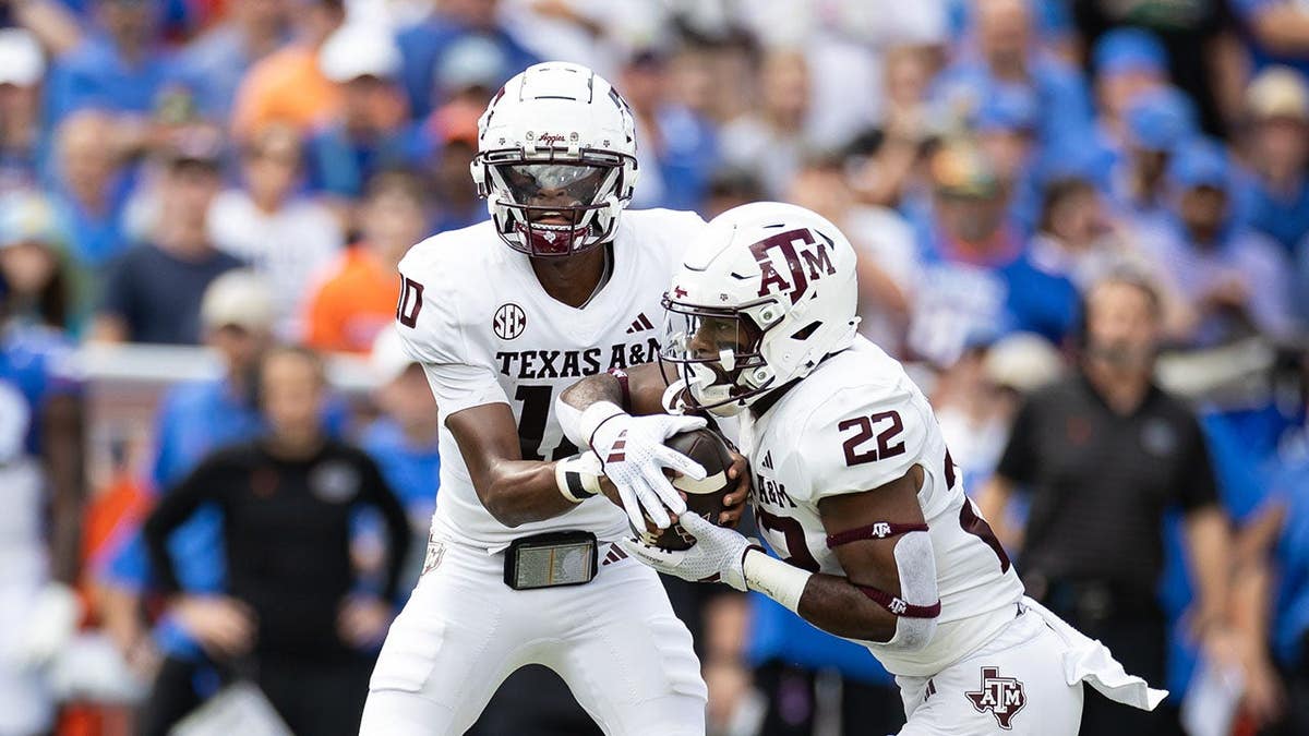 Texas A&M quarterback Marcel Reed handing ball to running back EJ Smith during football game