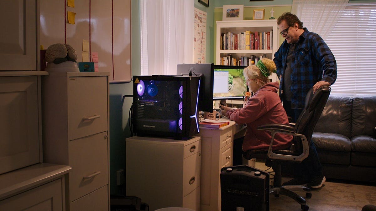 Christine Marie and Tolga Katas standing in a scene from Trust Me: The False Prophet Season 1