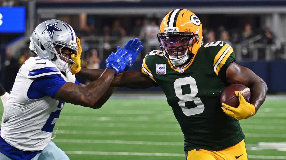 Green Bay Packers running back Josh Jacobs running with the ball while Dallas Cowboys cornerback Trikweze Bridges attempts a tackle