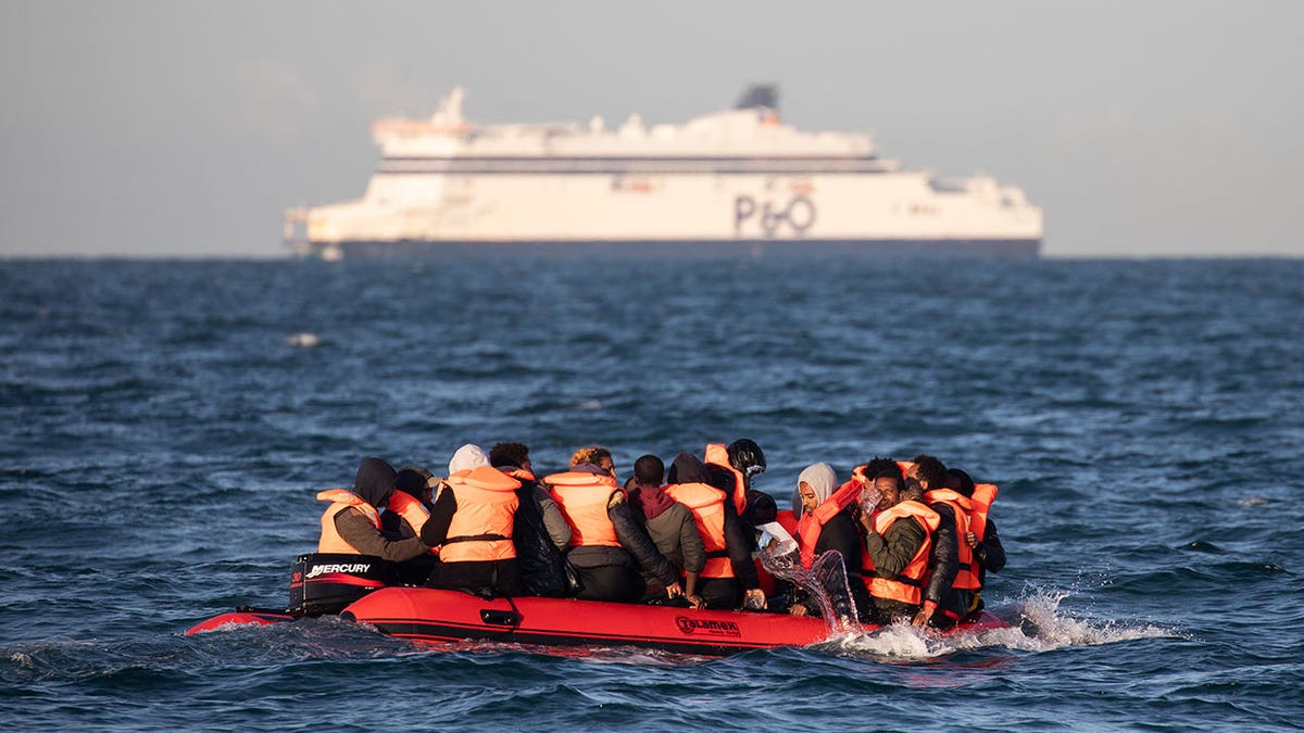 Migrants bailing water from a small inflatable boat near Dover Strait