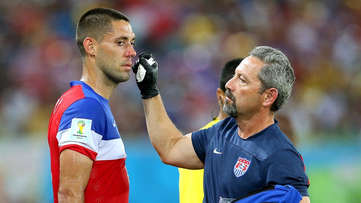 Clint Dempsey receiving treatment for a nose injury on the soccer field.