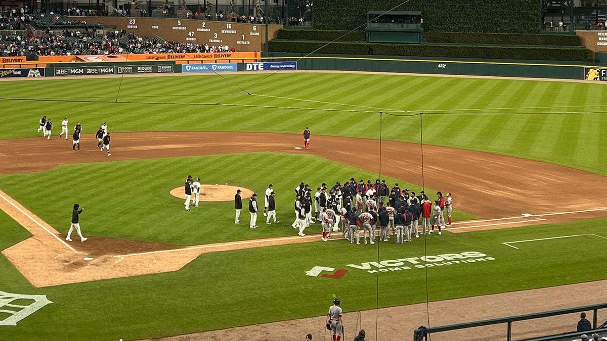 Players and coaches from Detroit Tigers and Boston Red Sox on Comerica Park field