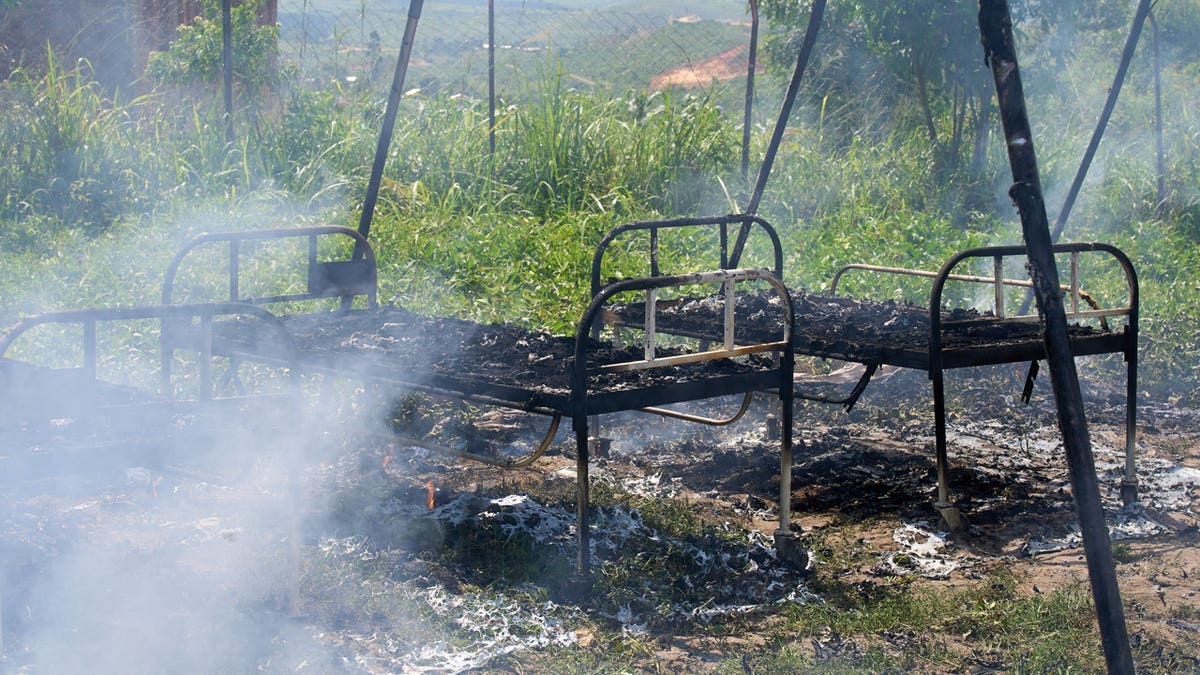 Charred hospital beds stand in smoldering Ebola treatment center in Rwampara, Congo