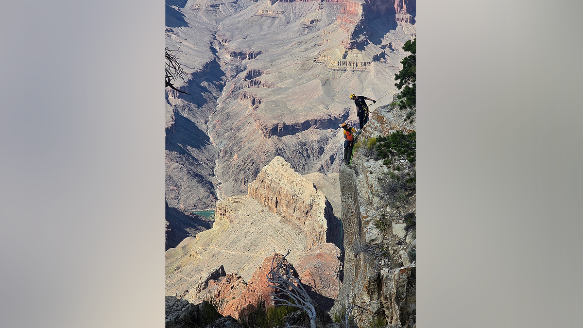 Search and rescue personnel work along a cliffside at the Grand Canyon during ongoing investigation