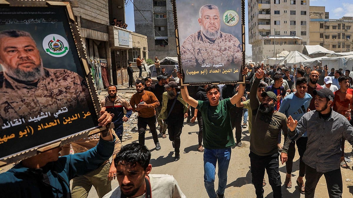 Mourners carrying images of Hamas military wing commander Izz al-Din al-Haddad during a funeral in Gaza City