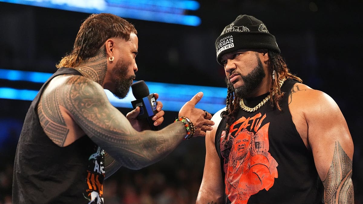 Jey Uso and Jacob Fatu speaking in wrestling ring during SmackDown event