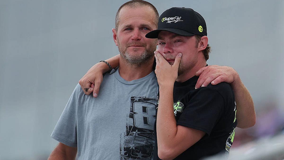 NASCAR fans reacting in grandstands during remembrance ceremony at Charlotte Motor Speedway