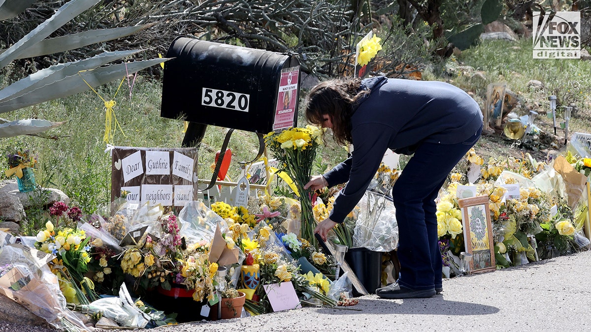 People placing flowers outside Nancy Guthrie's home in Tucson, Arizona