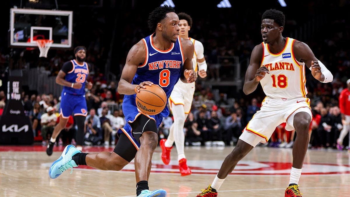 New York Knicks forward Og Anunoby driving past Atlanta Hawks forward Mouhamed Gueye during a basketball game
