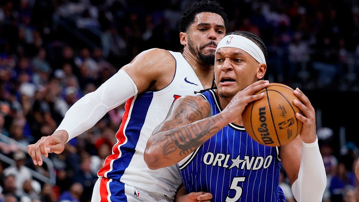 Orlando Magic forward Paolo Banchero driving to the basket against Detroit Pistons forward Tobias Harris