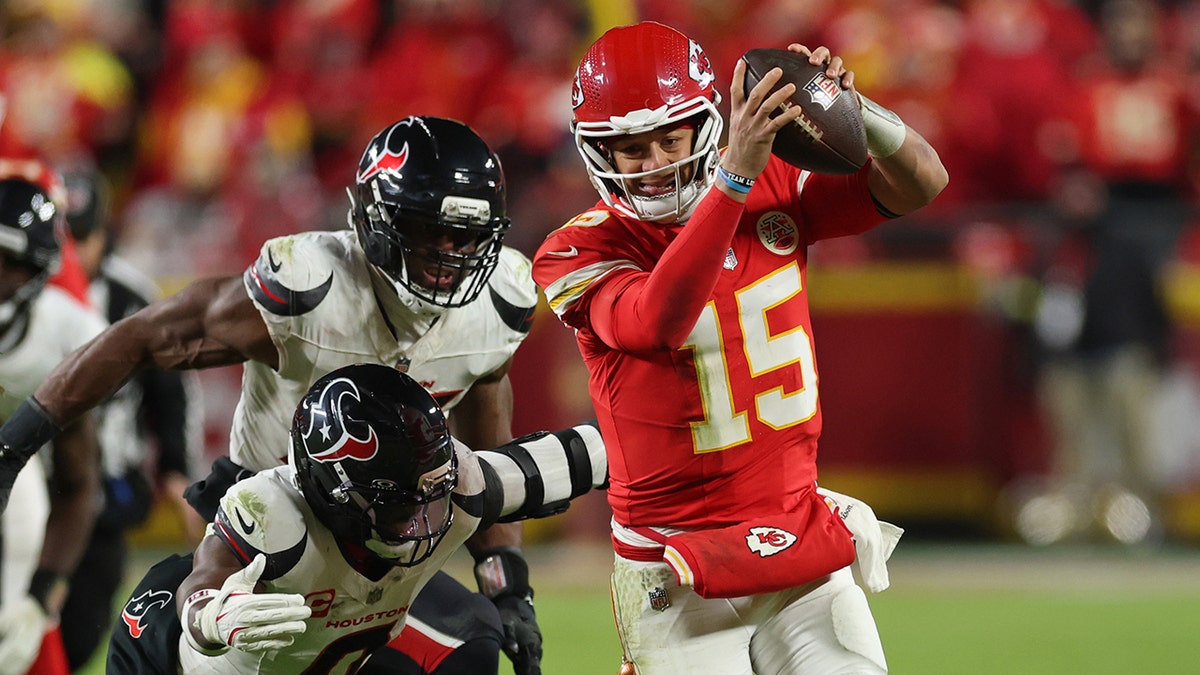 Patrick Mahomes running with the football past Danielle Hunter and Azeez Al-Shaair at Arrowhead Stadium