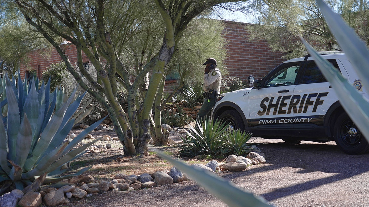 Pima County sheriff's official standing outside Nancy Guthrie's home in Tucson