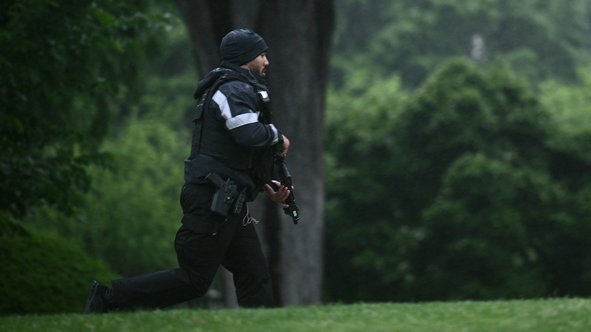 An armed Secret Service agent reacts at the White House