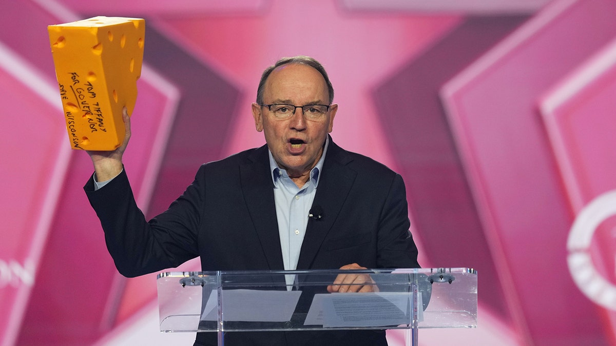 Wis. Rep. Tom Tiffany holding a cheesehead while speaking at AmericaFest 2025 in Phoenix