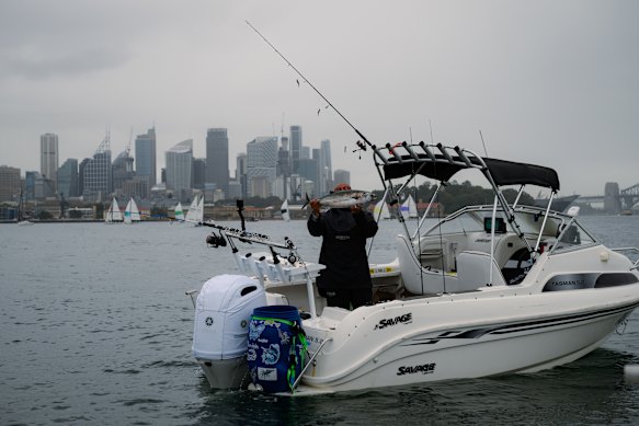 A fisher shows his catch to officers during a safety check on Sydney Harbour.