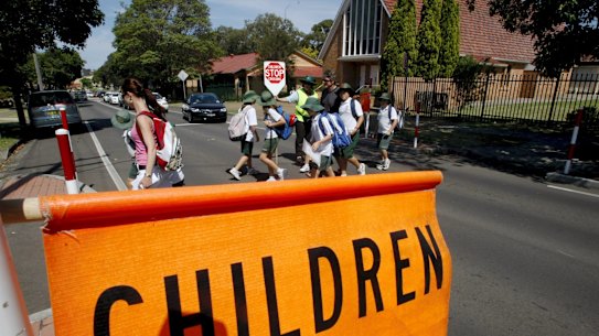 Children cross the road in a school zone. 