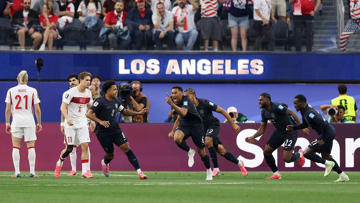 Auston Trusty celebrating with teammates after scoring a goal at Los Angeles Stadium.