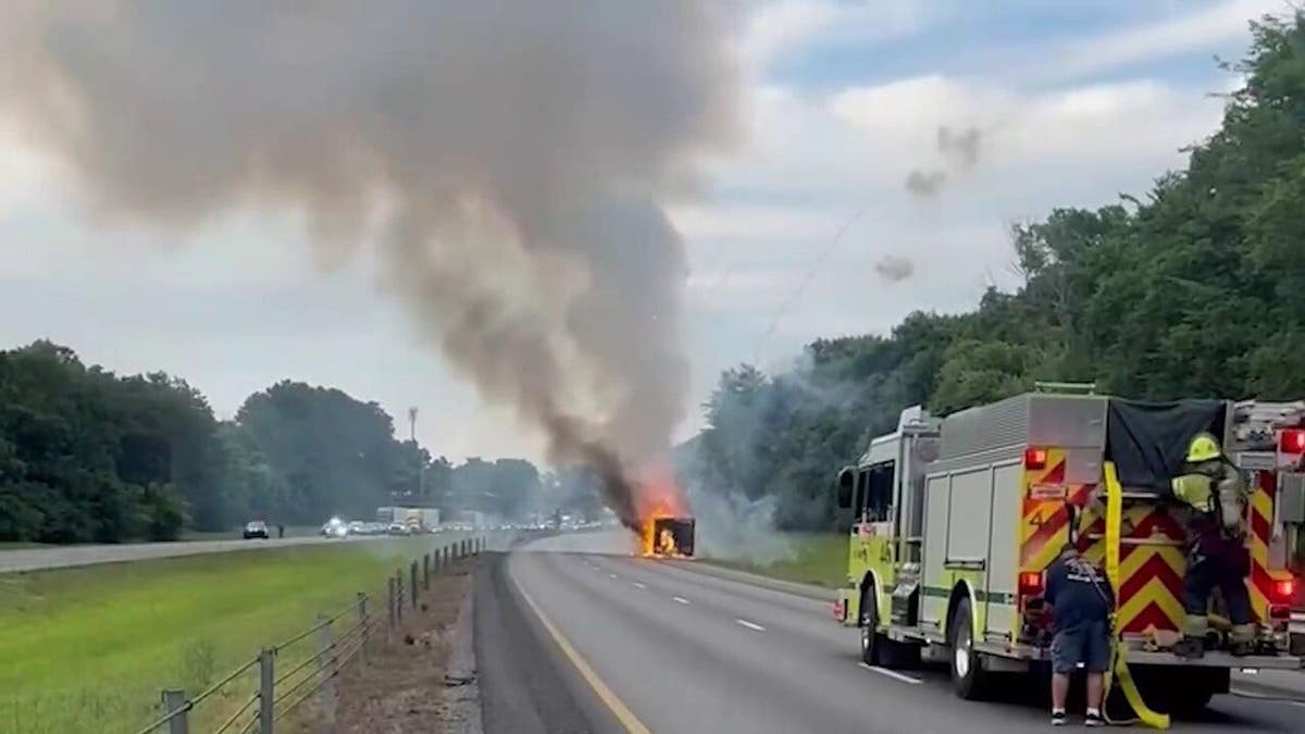 Smoke rises from a burning trailer carrying fireworks as firefighters respond on Interstate 75 in Tennessee.
