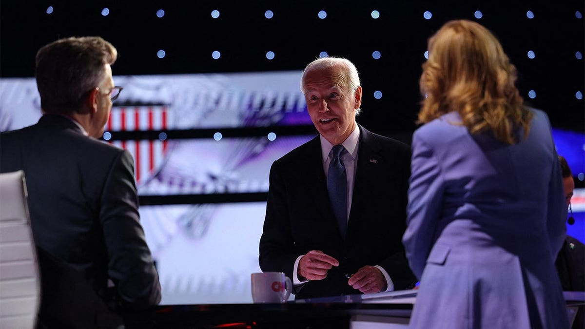 President Joe Biden speaking with moderator Jake Tapper as First Lady Jill Biden looks on