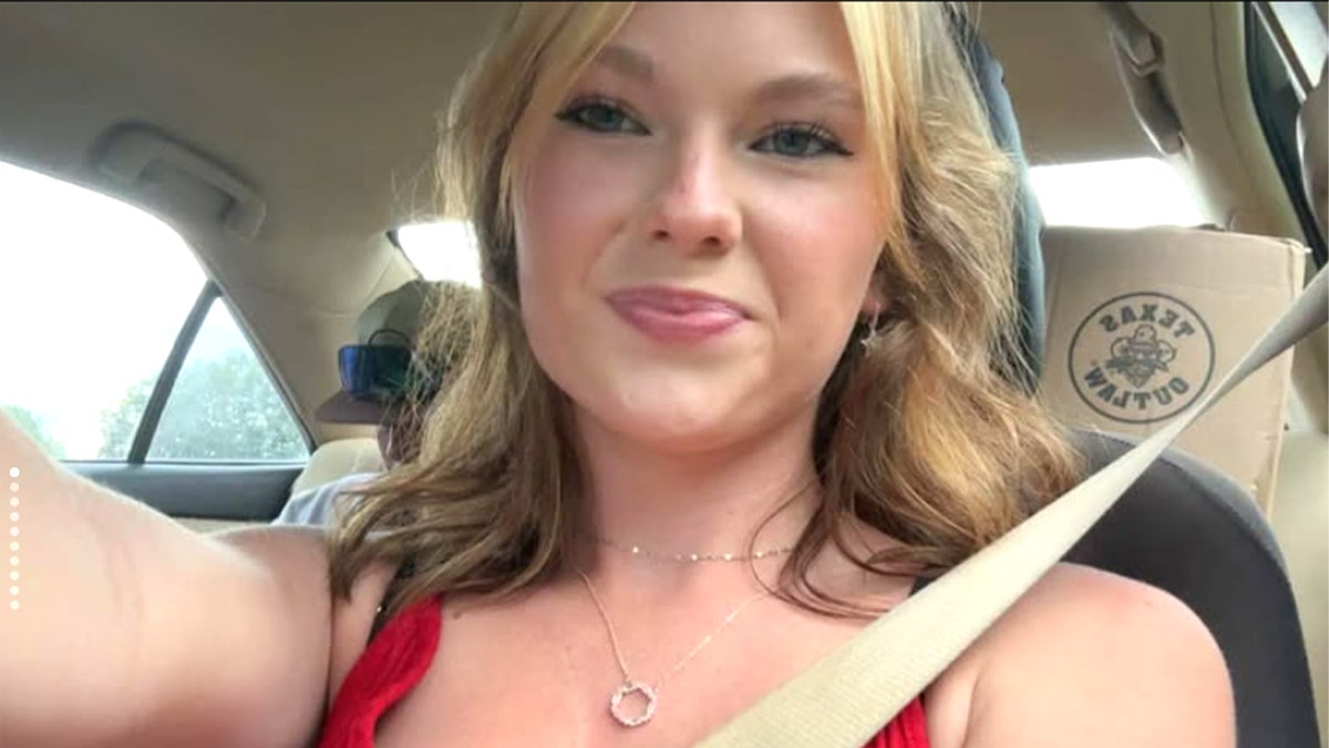 Anna Kepner taking a picture inside a car.