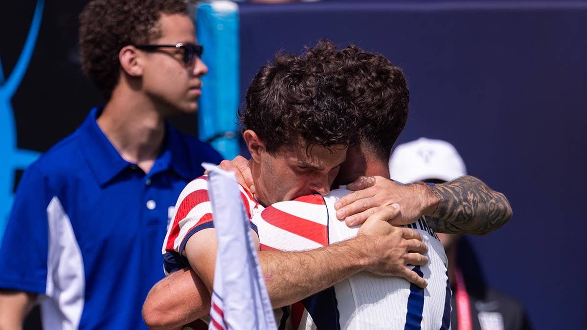 United States forward Christian Pulisic celebrating with midfielder Sebastian Berhalter on soccer field