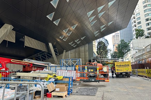 Some of the panel structures (the grey squares to the left) will descend to protect the station from flooding. The “green spine” open space here outside the station is expected to be open in August.