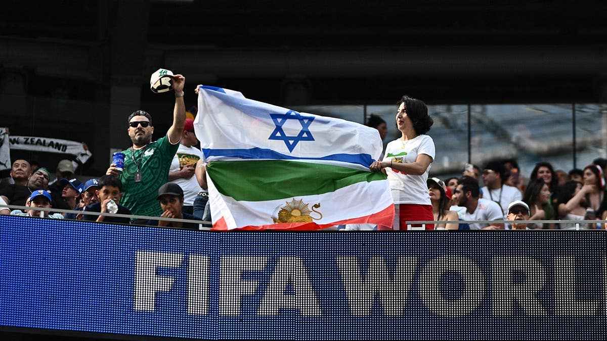 Fans of Iran posing with a pre-revolutionary Iranian flag joined with an Israel flag at Los Angeles Stadium.